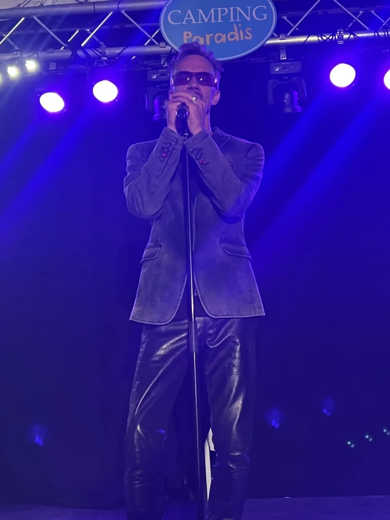 Artiste sur scène chantant avec un micro.