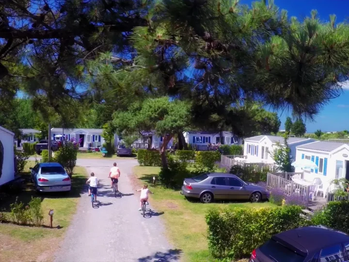 Enfants faisant du vélo dans un camping en été.