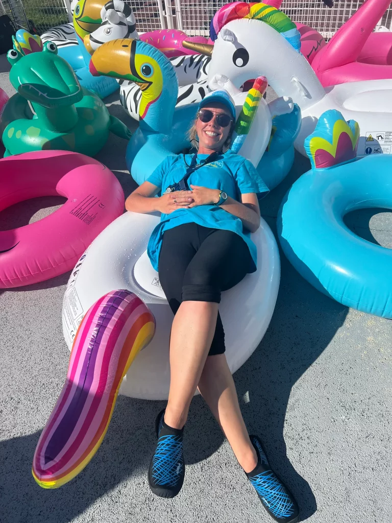 Femme détendue sur des bouées colorées à la piscine.