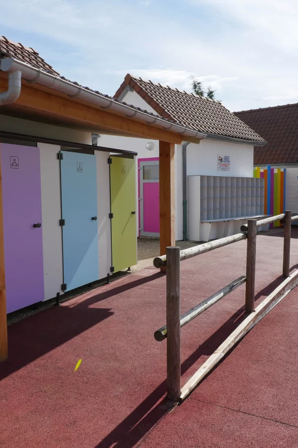 Allée menant à des cabines de toilette colorées.