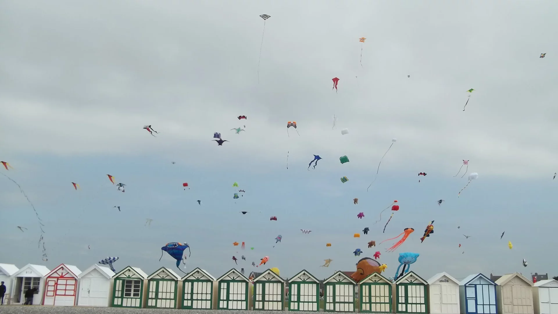 Cerfs-volants colorés dans un ciel nuageux.
