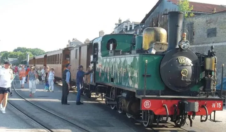 Locomotive à vapeur avec passagers et chemin de fer.