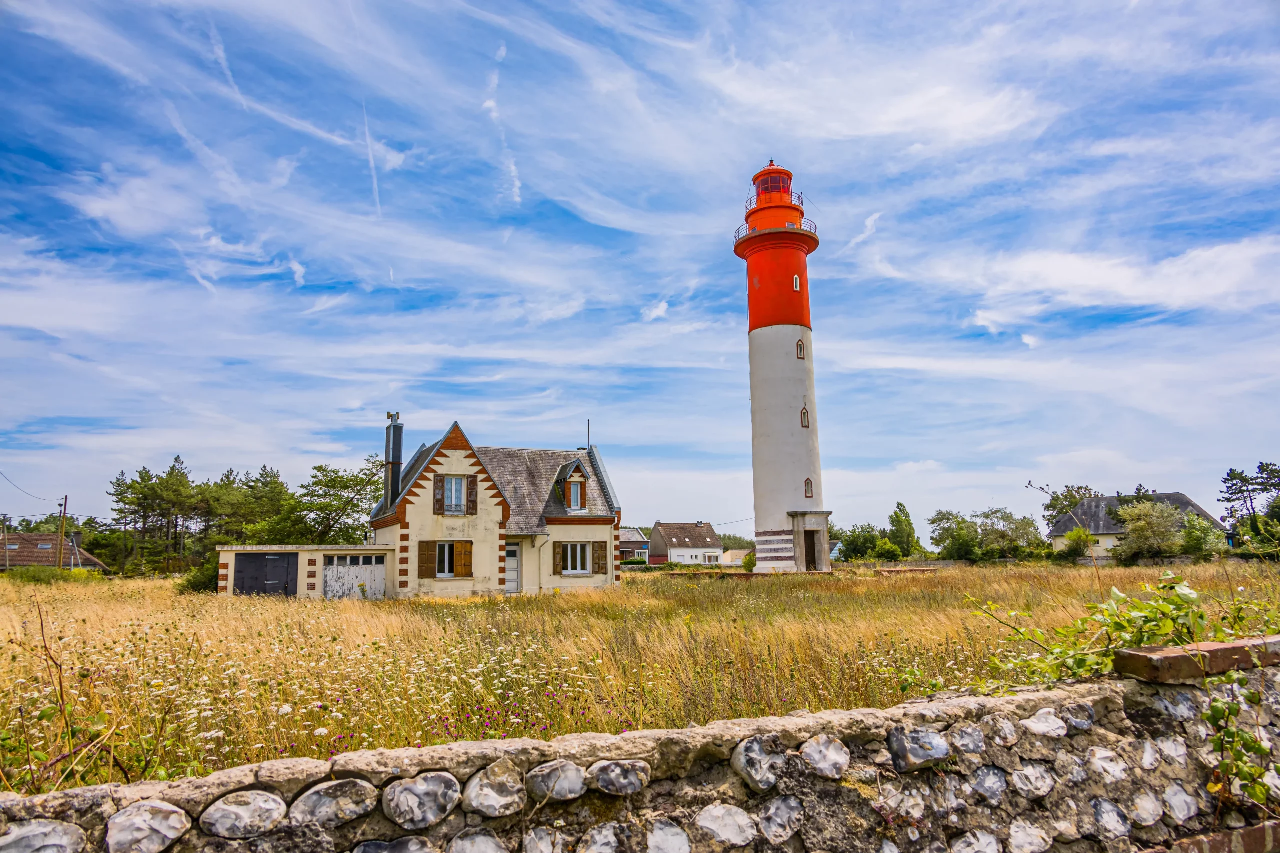 Phare orange près d'une maison dans un champ