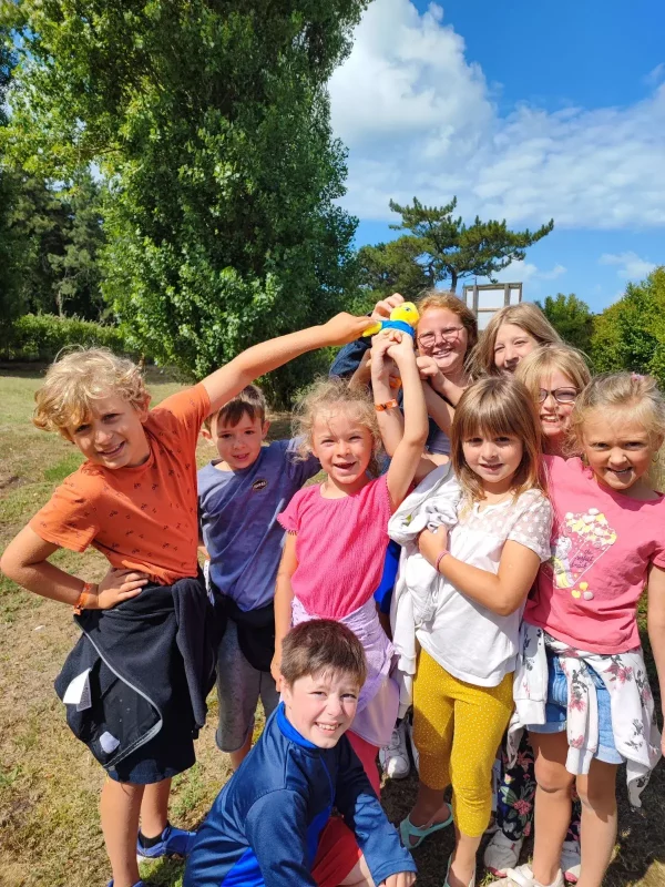 Groupe d'enfants souriants avec un jouet.