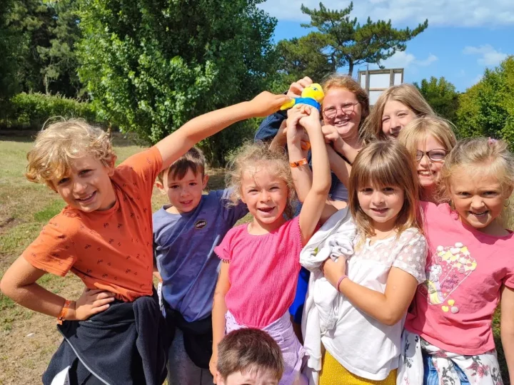 Groupe d'enfants souriants avec un jouet.
