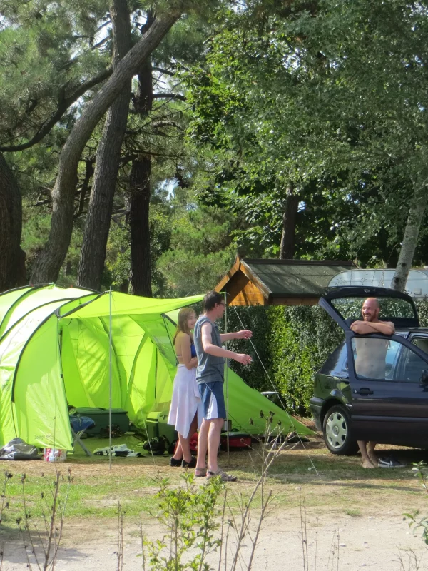 Camping sous un ciel ensoleillé avec tente verte.