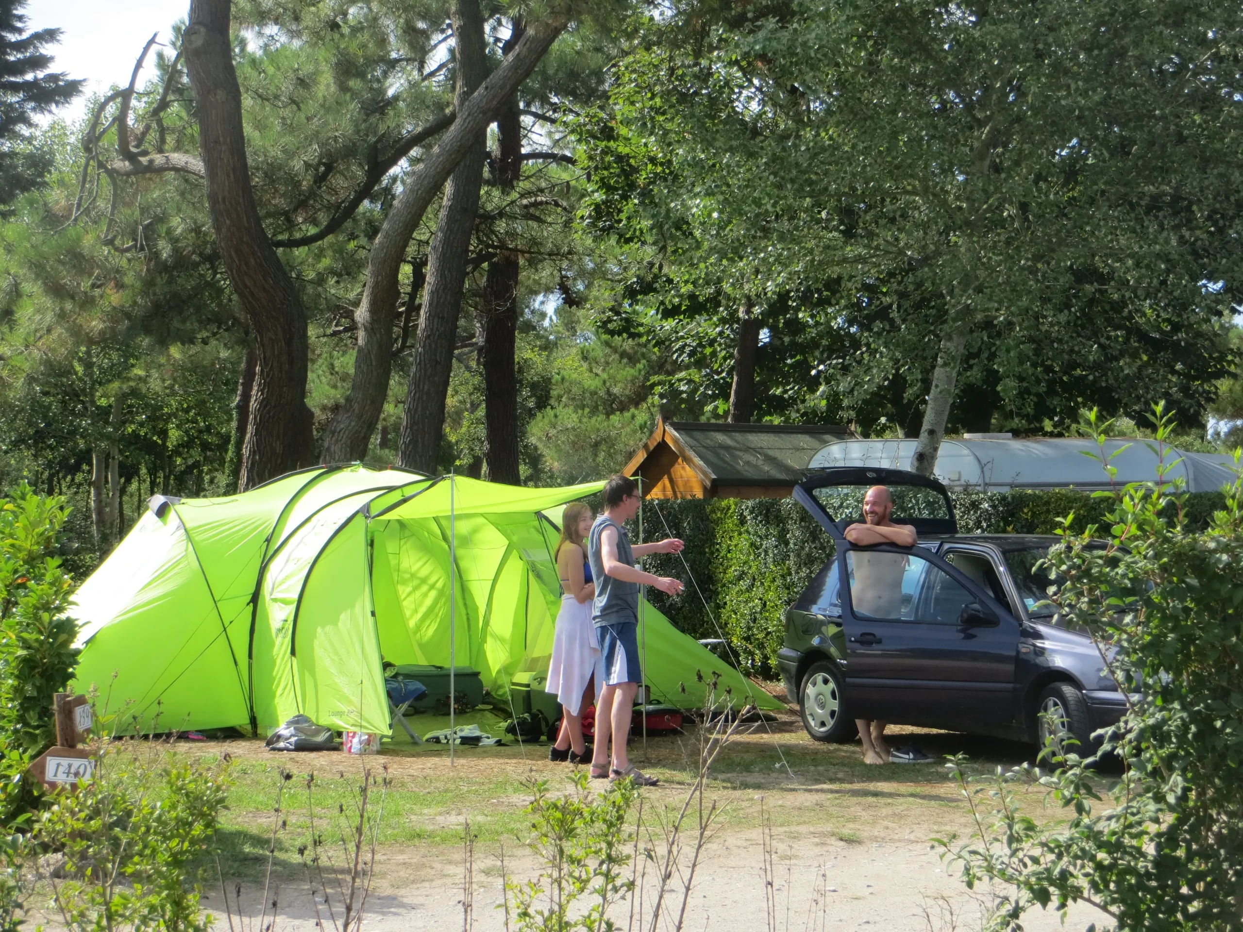 Camping sous un ciel ensoleillé avec tente verte.