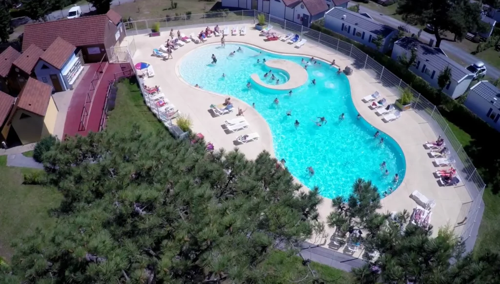 Vue aérienne d'une piscine entourée de personnes.