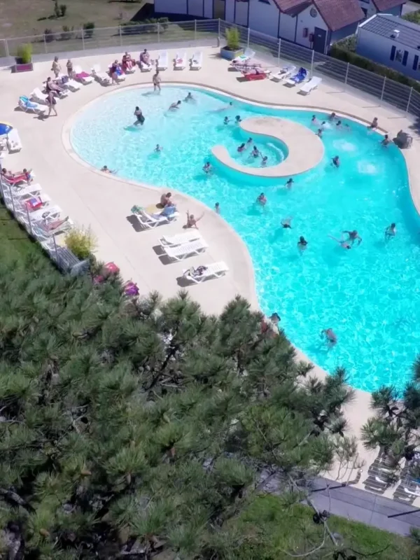 Vue aérienne d'une piscine entourée de personnes.