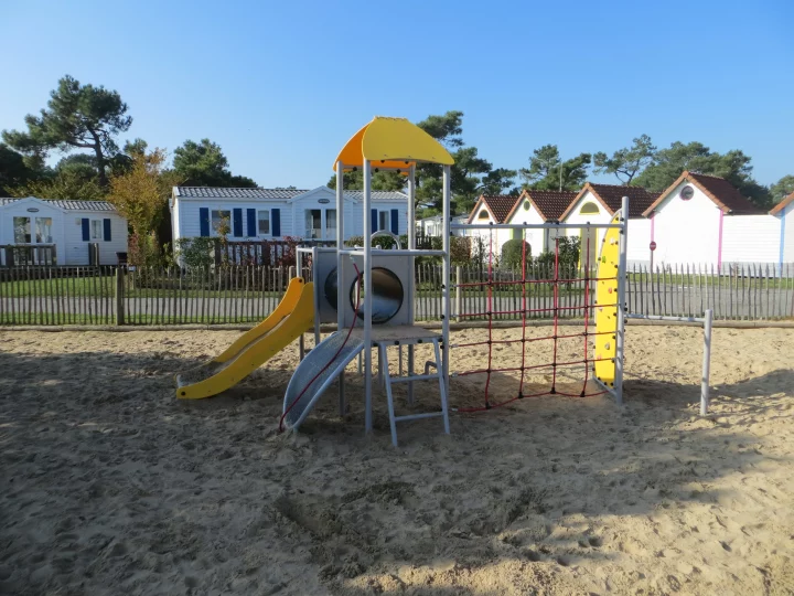Aire de jeux avec toboggan et grimpeur.