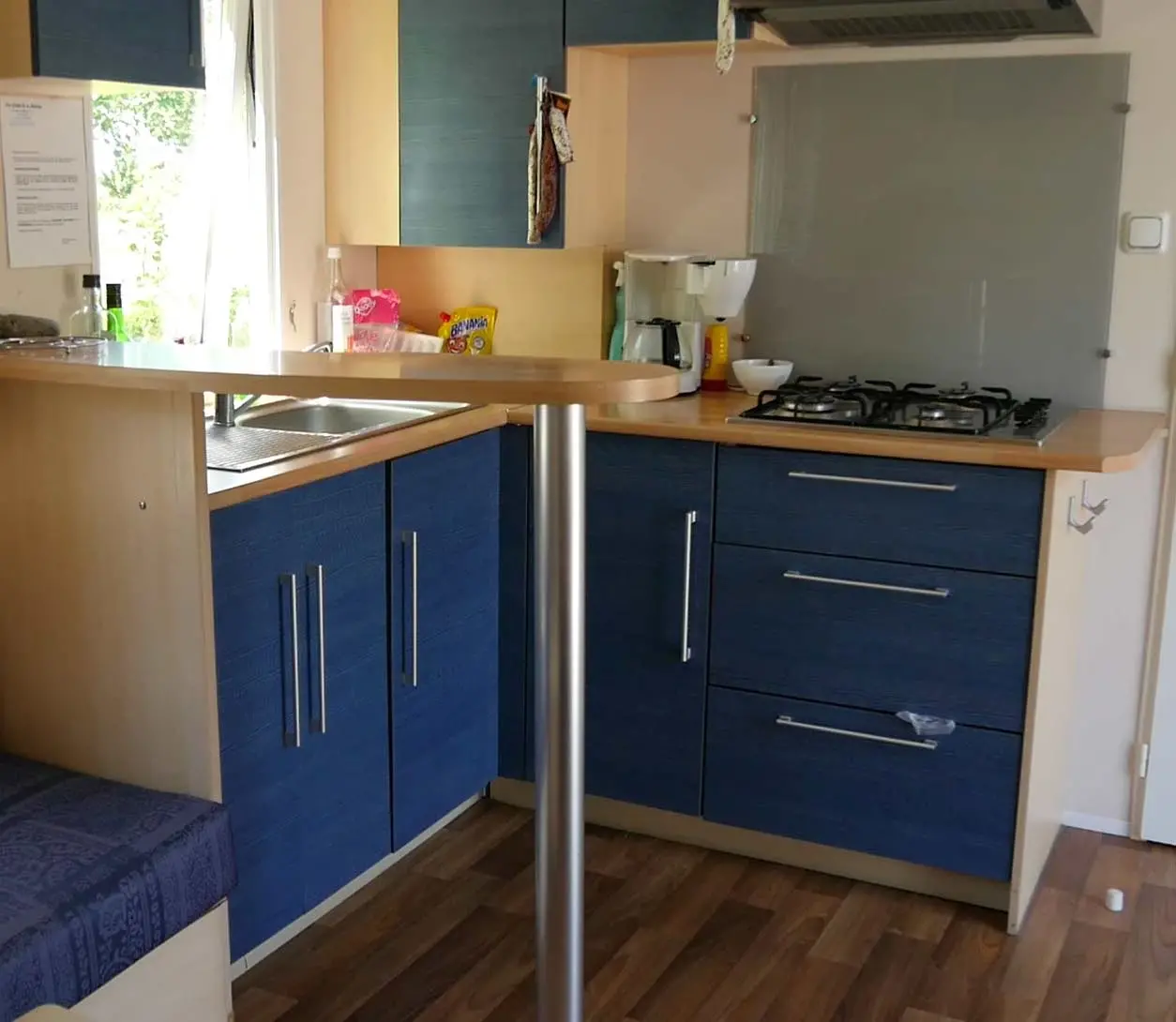 Cuisine moderne avec armoires bleu et plan de travail.