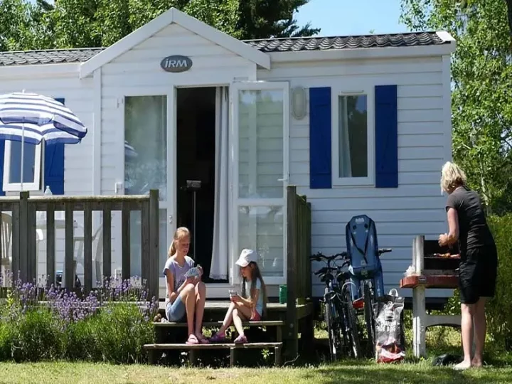 Famille devant un chalet en pleine nature.