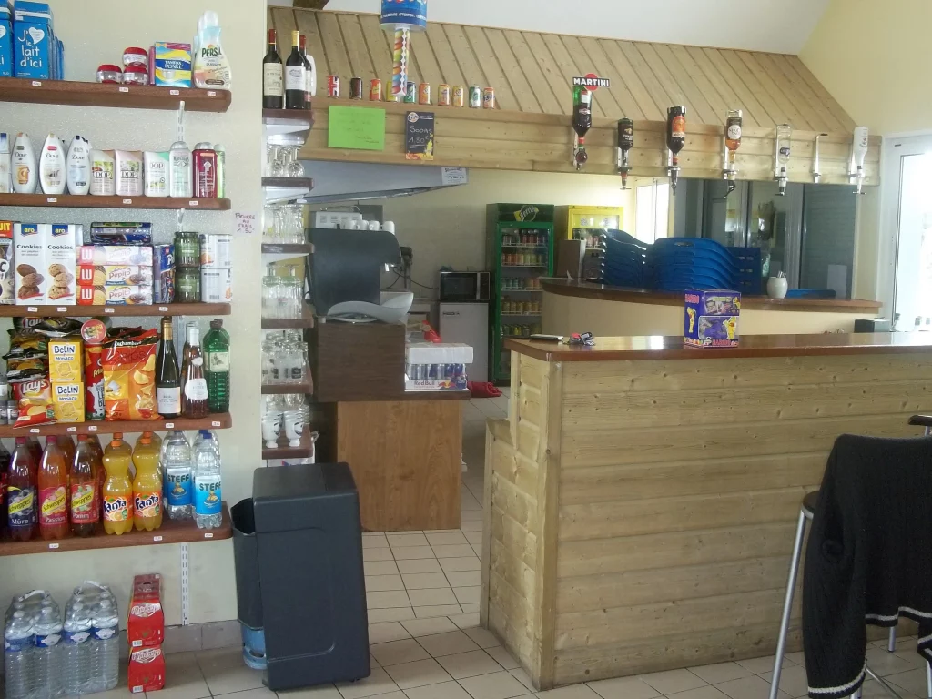 Intérieur d'un magasin avec étagères et comptoir.