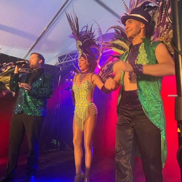 Spectacle vivant avec chanteurs et danseurs colorés.