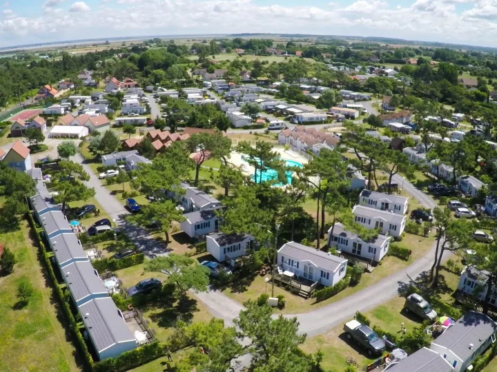 Vue aérienne d'un village de vacances verdoyant.